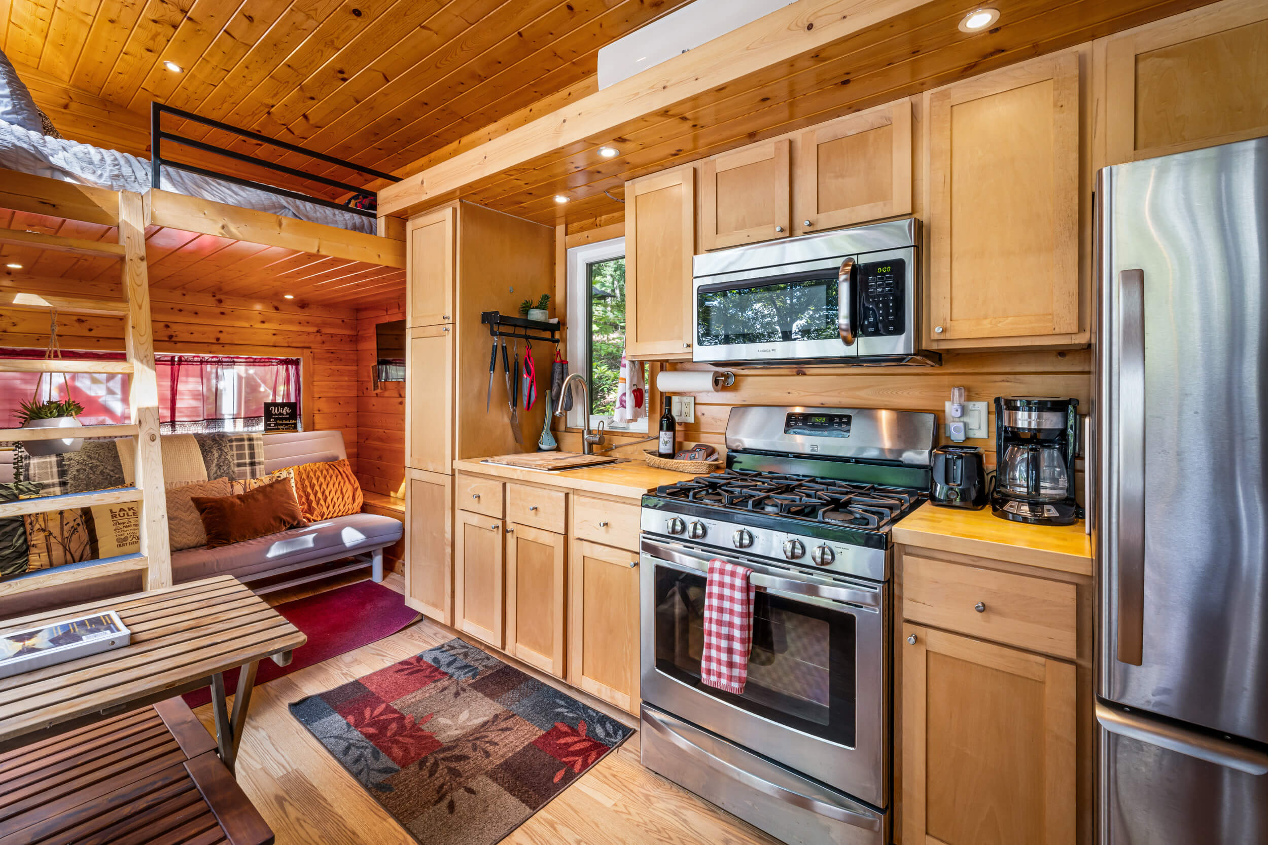 Inside you'll find a small living room area with a futon that turns into a surprisingly comfy queen bed; loft queen sized beds at either end, and full residential sized refrigerator, stove, and microwave.