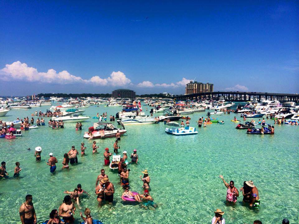 Destin, Florida. Known for its white sand beaches, crystal-clear ocean and exceptional fishing, this Panhandle town is the most popular destination on Florida’s Emerald Coast, drawing about 3.6 million visitors each year.
One of the brightest jewels in Destin’s crown is Crab Island, a submerged sandbar in Choctawhatchee Bay, five minutes by boat from Destin Harbor also known as Crab Island Covered in just 1-4 feet of water that’s brilliant turquoise during high tide and clear emerald green the rest of the time, it’s like a four-acre swimming pool where visitors can wade, snorkel, play and relax.